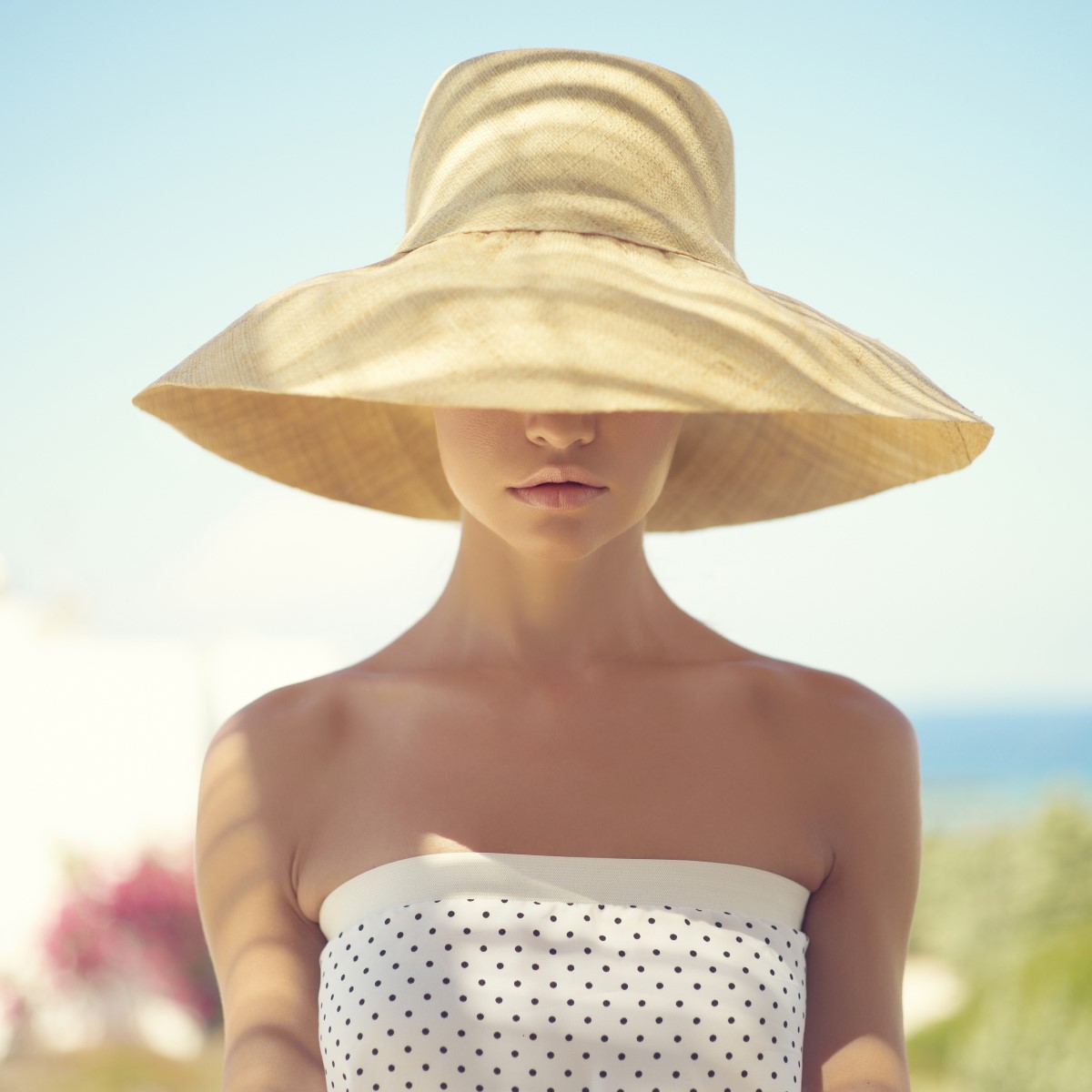 Beautiful young lady in straw hat in the sunlight