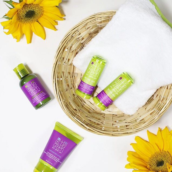 Little Green products in a basket with flowers 
