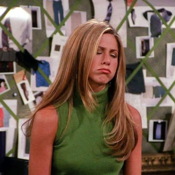 Rachel green with long straight blonde hair pouting in a green tank top